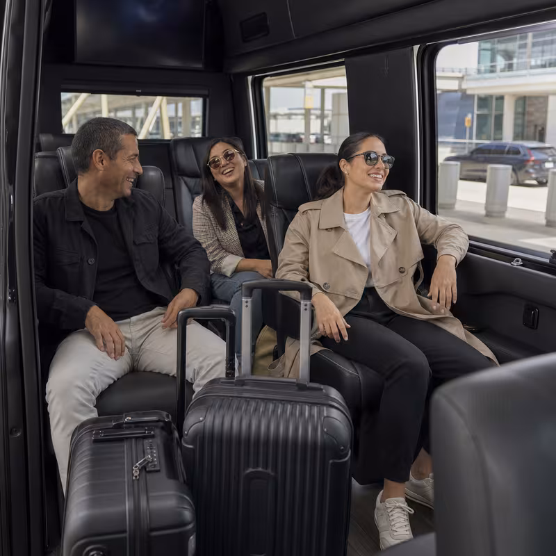 Passengers loading luggage while boarding an Fort Worth group shuttle